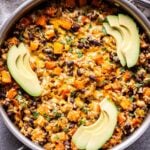Southwest Sweet Potato, Black Bean and Rice Skillet topped with slices of avocado.