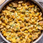 Green Chile Chicken and Potatoes in a skillet topped with melted cheese.