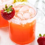 Strawberry Mezcal Margarita with a strawberry next to it and a squeezed lime behind it.