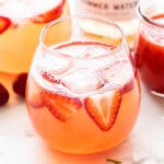 Strawberry Rosé Spritzer with strawberries in front of it and a bottle of rosé behind it.