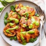Grilled Chicken with Basil Dressing on a gray plate with two forks. A jar of the dressing is behind the plate.