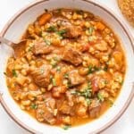 Beef and Barley Soup in a white bowl with a spoon.