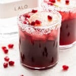 Pomegranate Margaritas with a bottle of tequila in the background.