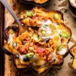 Half of a Southwest Stuffed Acorn Squash with a fork in the black bean and rice filling.