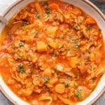 A white bowl with Cabbage Roll Soup in it and a spoon.