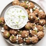 Greek Meatballs with Tzatziki Sauce on a gray plate.