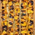 Honey chipotle chicken and pineapple skewers on a sheet pan.