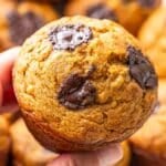 Hand holding up a pumpkin banana muffin.