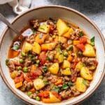 Hamburger Soup in a white bowl with a spoon.