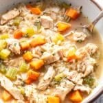 Chicken and Rice Soup in a white bowl with a spoon.