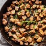 Garlic butter steak bites in a cast iron skillet.
