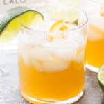 Skinny margarita in a glass with a salted rim and a lime wedge.