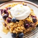 Slice of Lemon Blueberry Baked Oatmeal on a white plate topped with Greek yogurt.