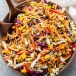 Thai Chicken Salad in a serving bowl with wooden serving spoons.