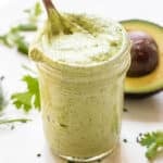 Avocado Ranch Dressing in a jar with a spoon.