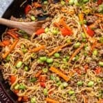 Ground beef ramen noodles in a skillet with a wooden spatula.
