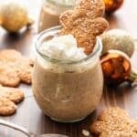 A jar of Gingerbread Overnight Oats topped with whipped cream and a gingerbread cookie.