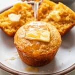 Honey being drizzled on top of a cornbread muffin.
