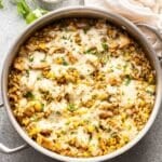 Salsa Verde Chicken and Rice in a skillet with a bowl of cilantro behind it.