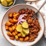 Sloppy joe bowl with ground beef, sweet potatoes, pickles and red onions.