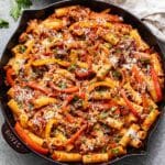 Italian sausage and peppers pasta with tomato sauce in a skillet.