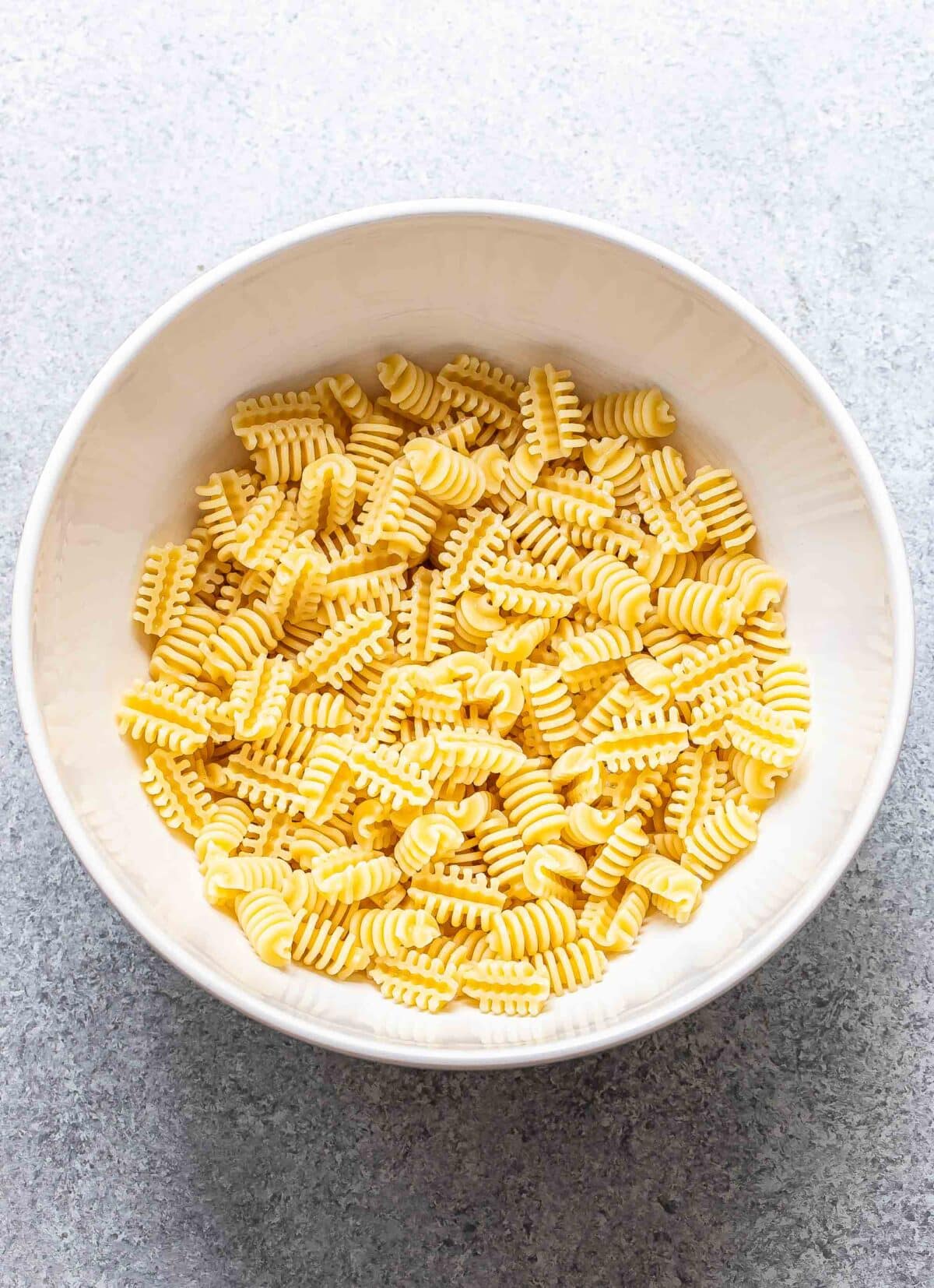 Radiatore pasta in a white mixing bowl.