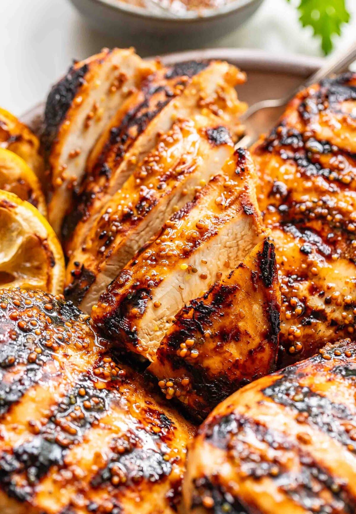 A sliced grilled honey mustard chicken breast on a plate.
