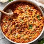 Ground beef pasta in a skillet with a wooden spoon.