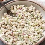 Dill pickle chicken salad in a white bowl with a fork in it.