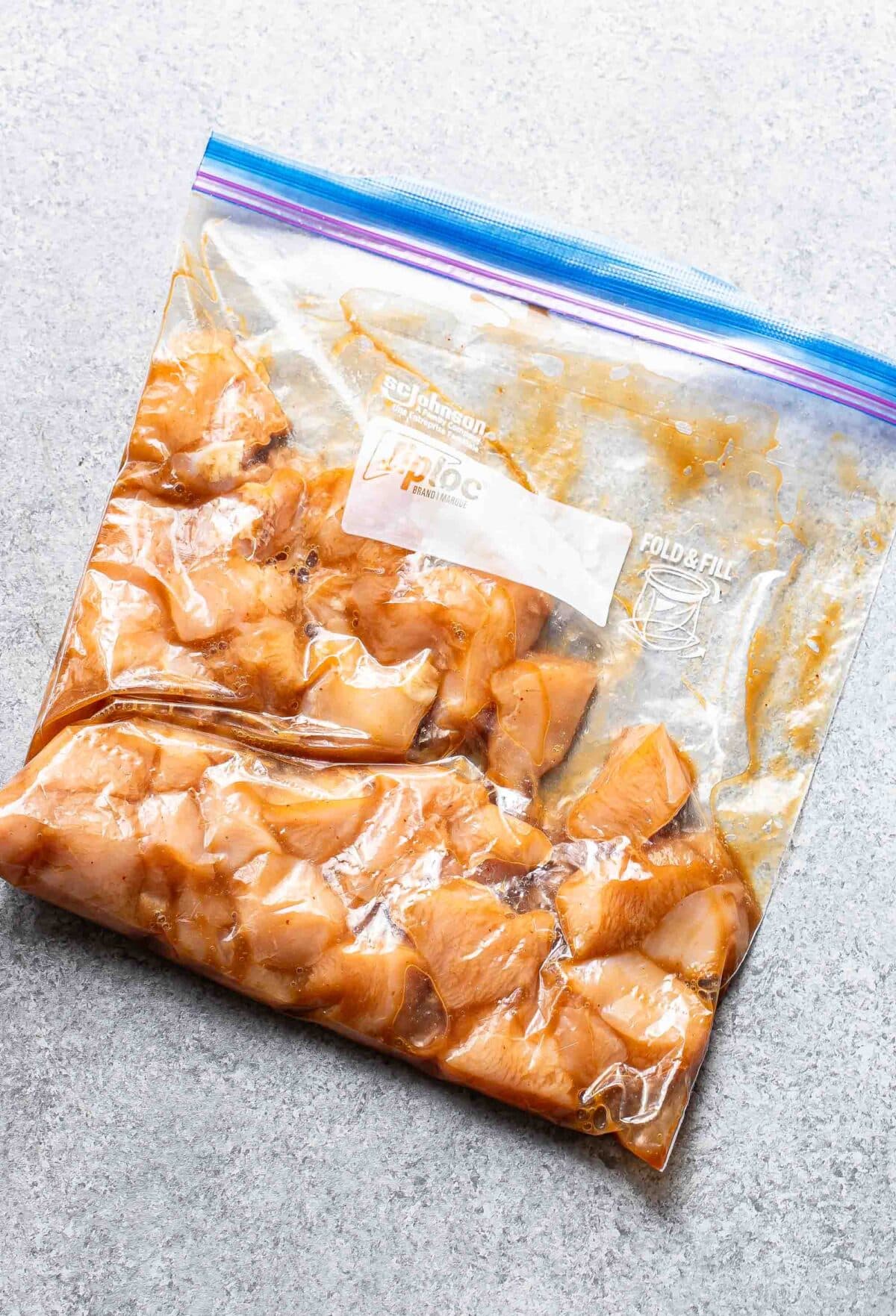 Marinated teriyaki chicken in a plastic freezer bag.