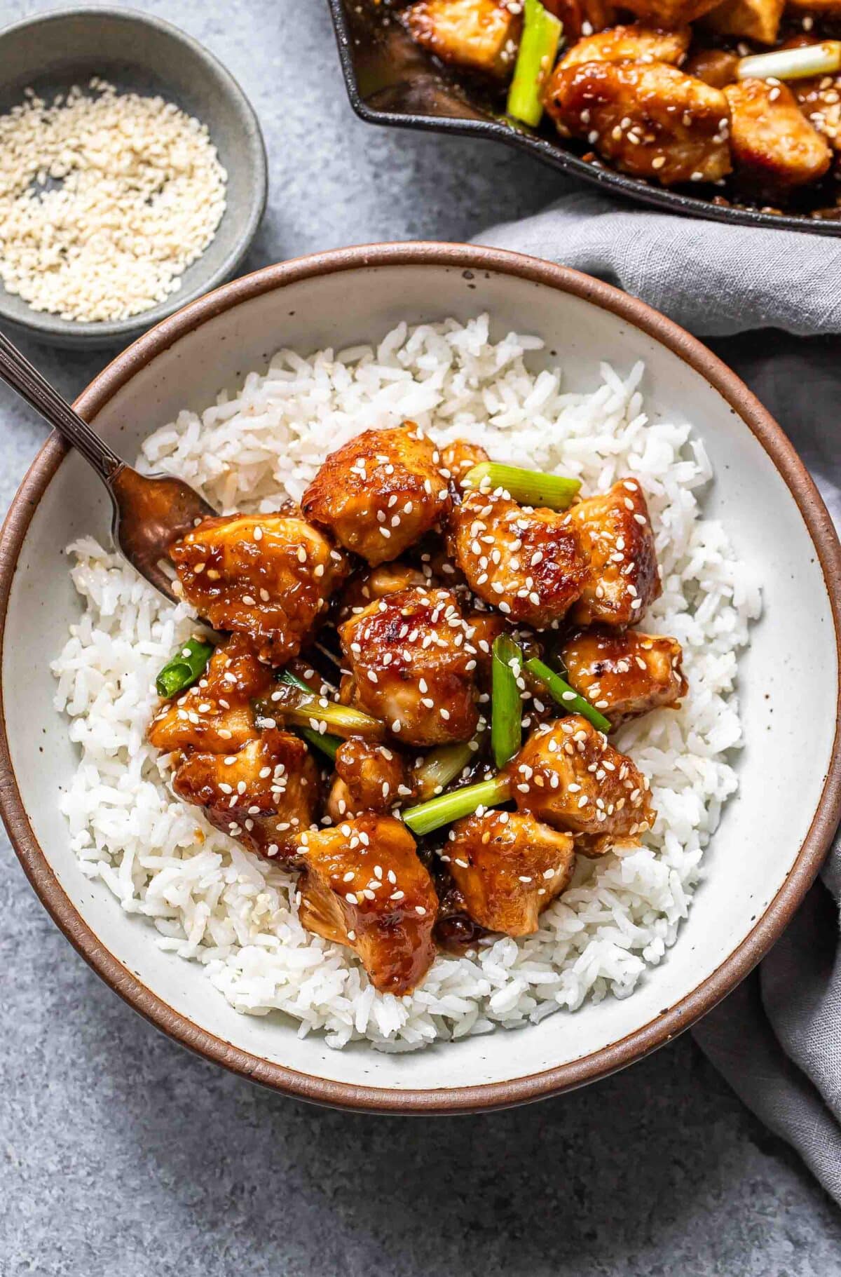 Mongolian chicken in a white bowl on top of rice.