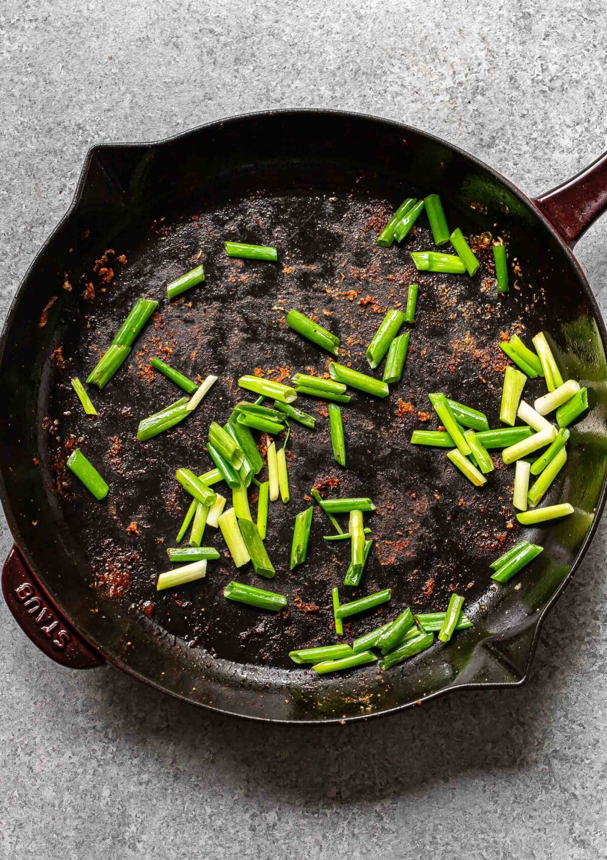 Sliced scallions in a skillet.