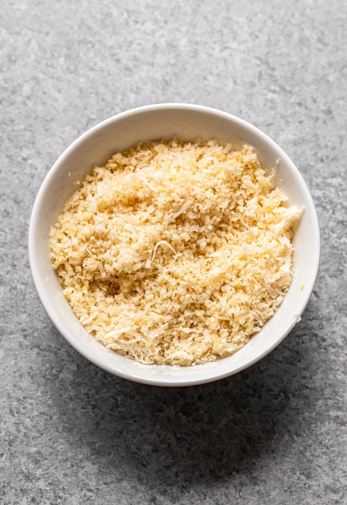 Panko and parmesan cheese in a white bowl.