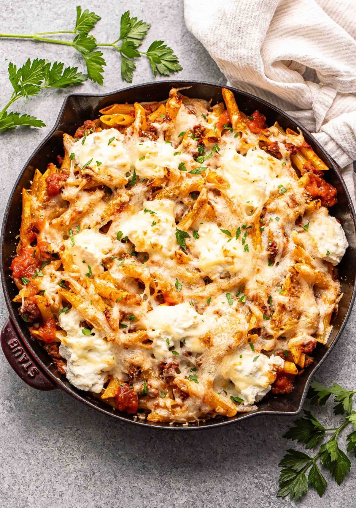 Baked penne with ground beef and ricotta cheese in a skillet.