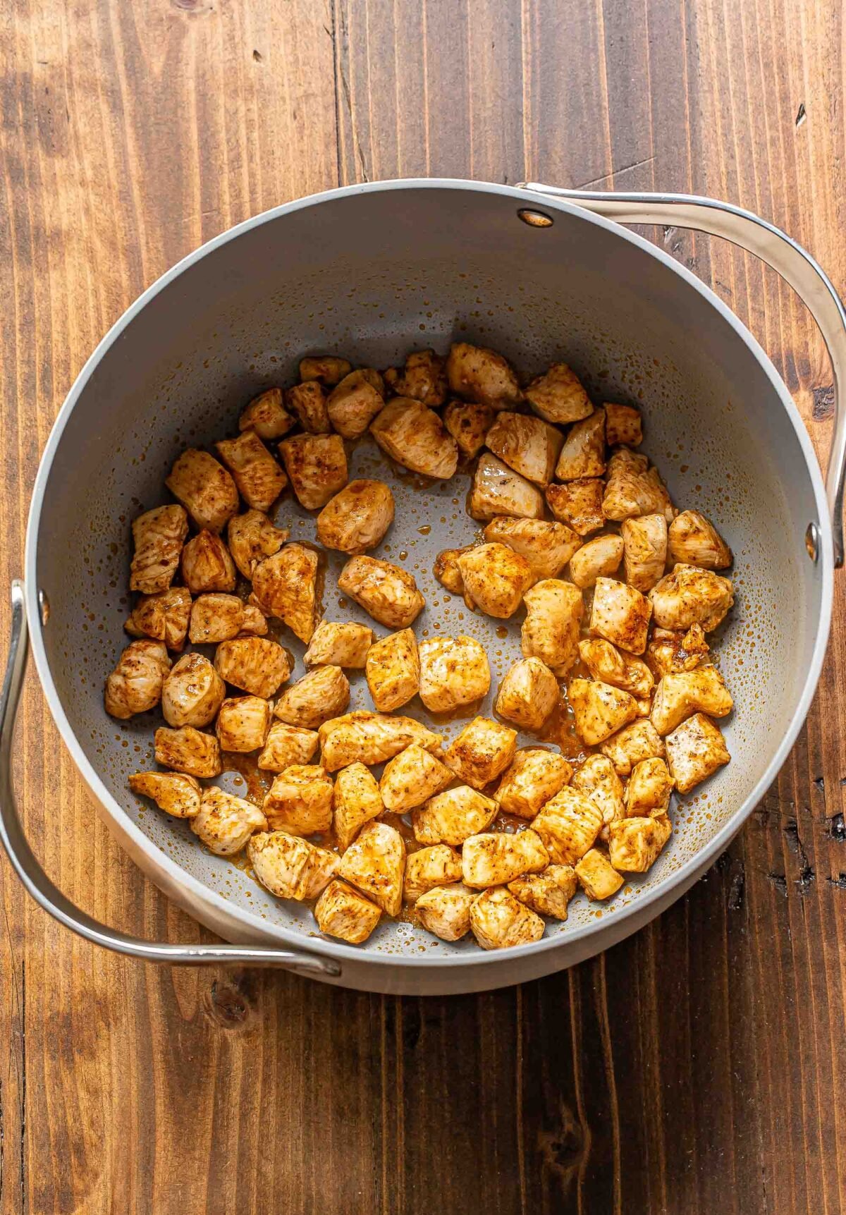 Chunks of cooked chicken in a pot.