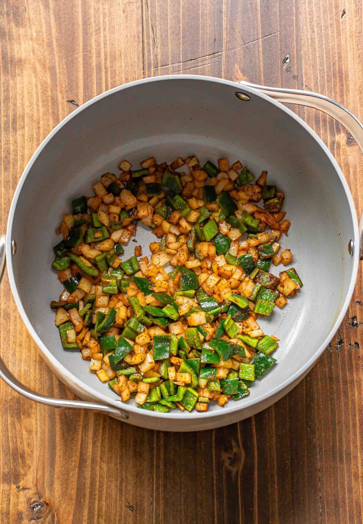 Sauteed pepper and onion in a pot.