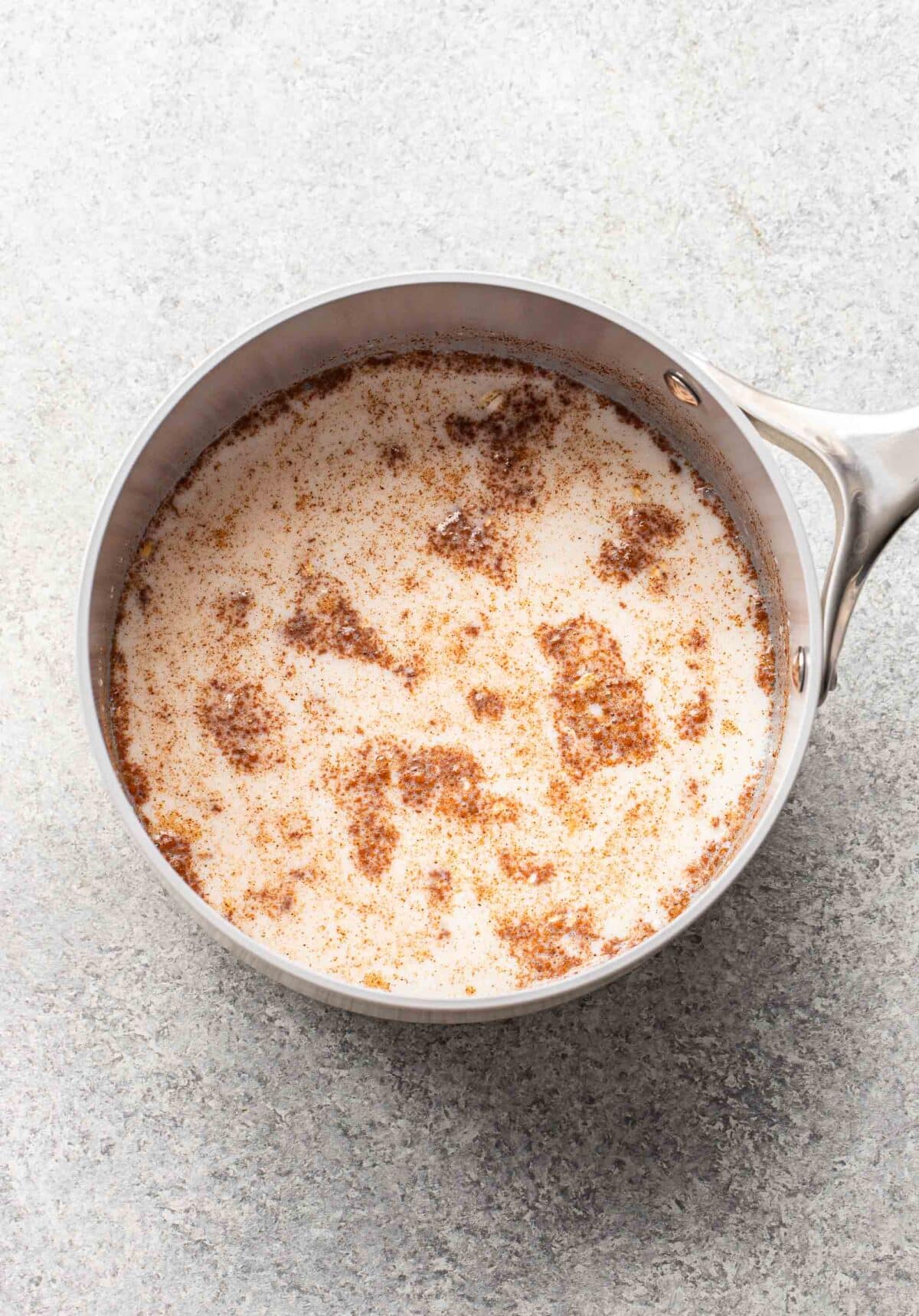 Oats, milk, and cinnamon in a saucepan.