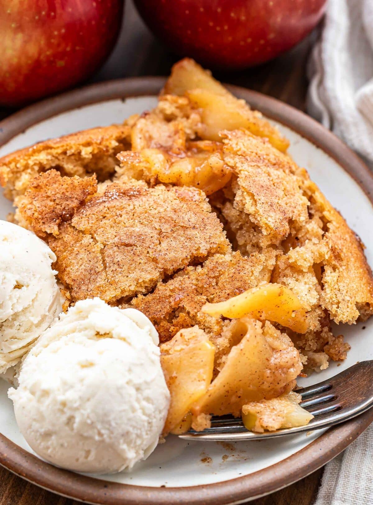 A white plate with apple cobbler and vanilla ice cream on it.