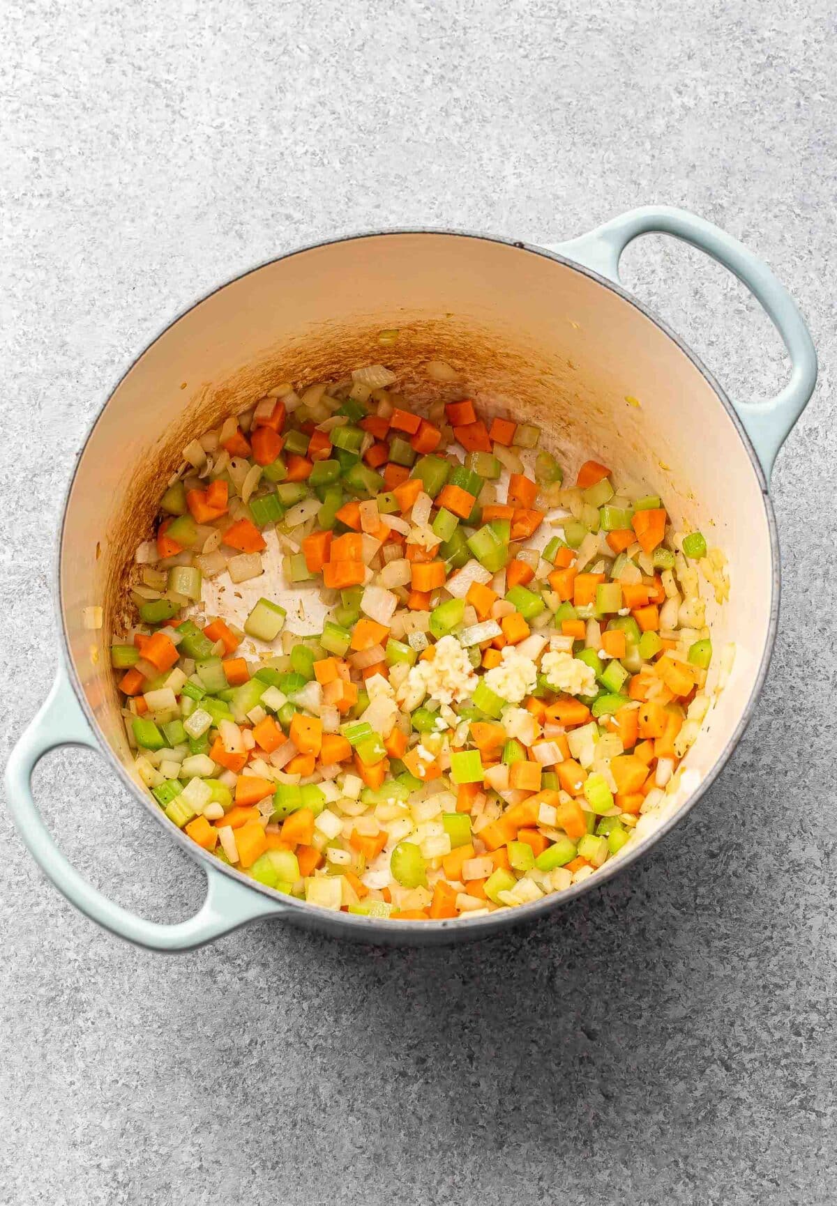 carrots, celery, and onion in a pot.