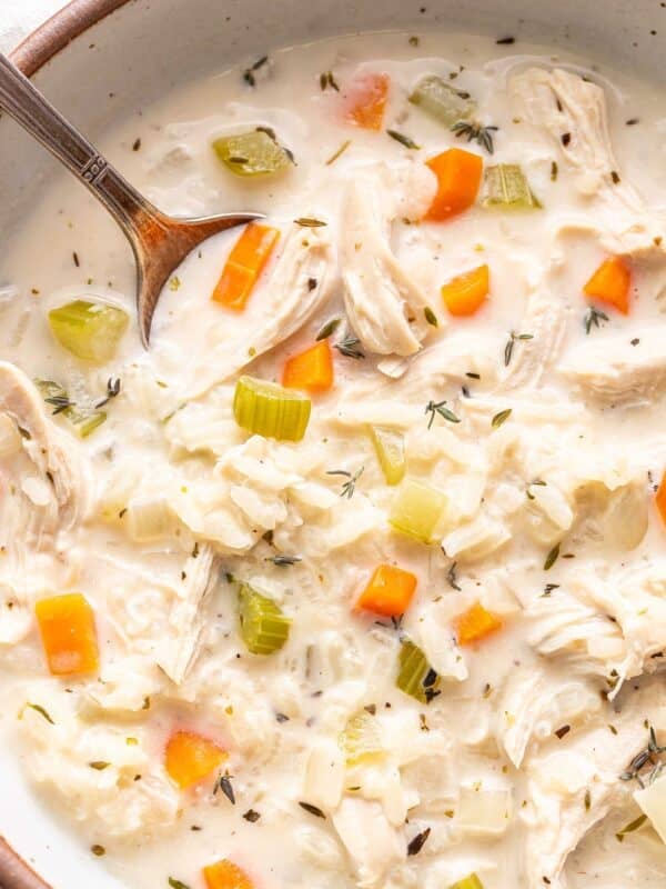 Creamy chicken and rice soup in a bowl with a spoon.