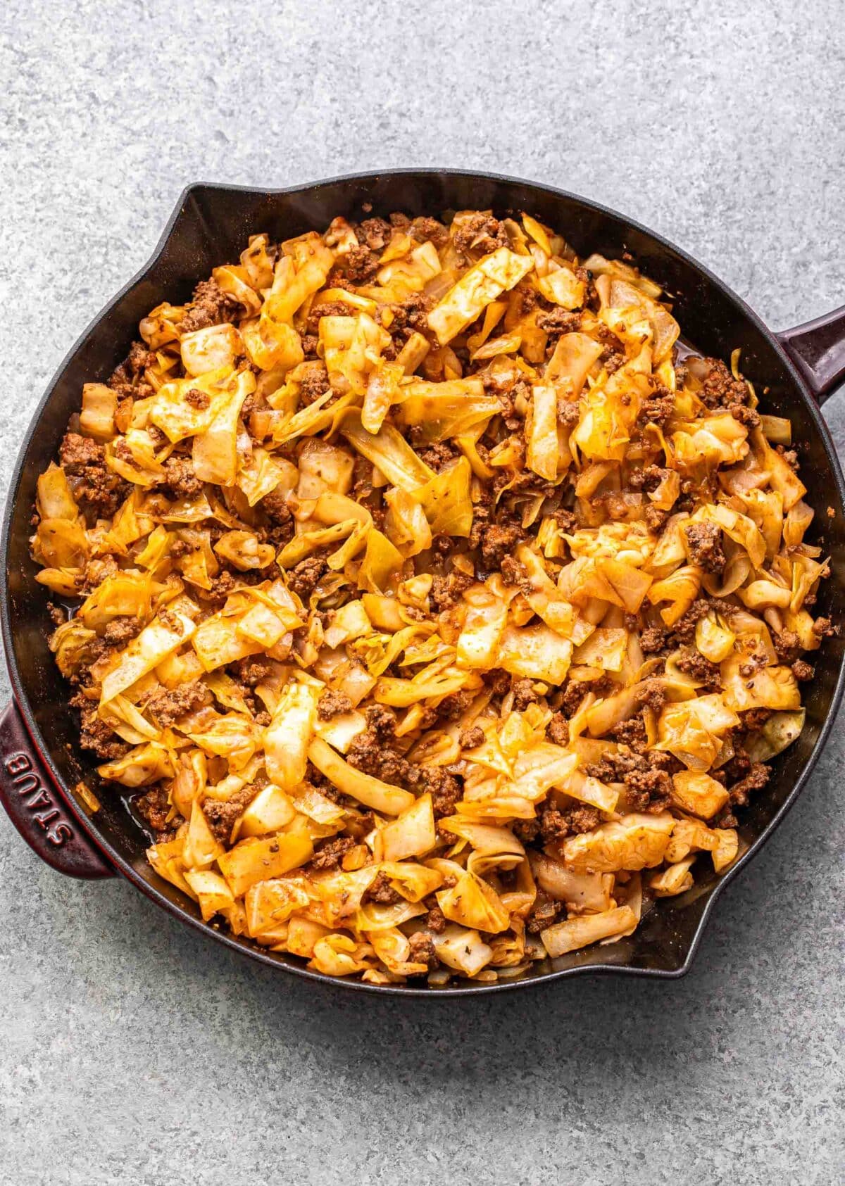 Skillet with ground beef and cabbage in it.