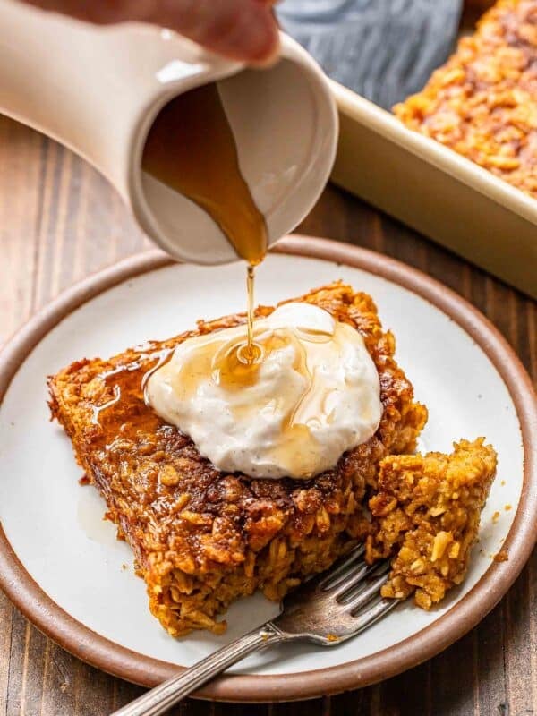 Maple syrup being poured onto a piece of pumpkin baked oatmeal.