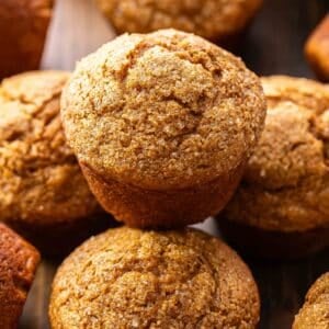 A pumpkin muffin stacked on top of other pumpkin muffins.
