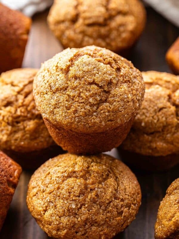 A pumpkin muffin stacked on top of other pumpkin muffins.