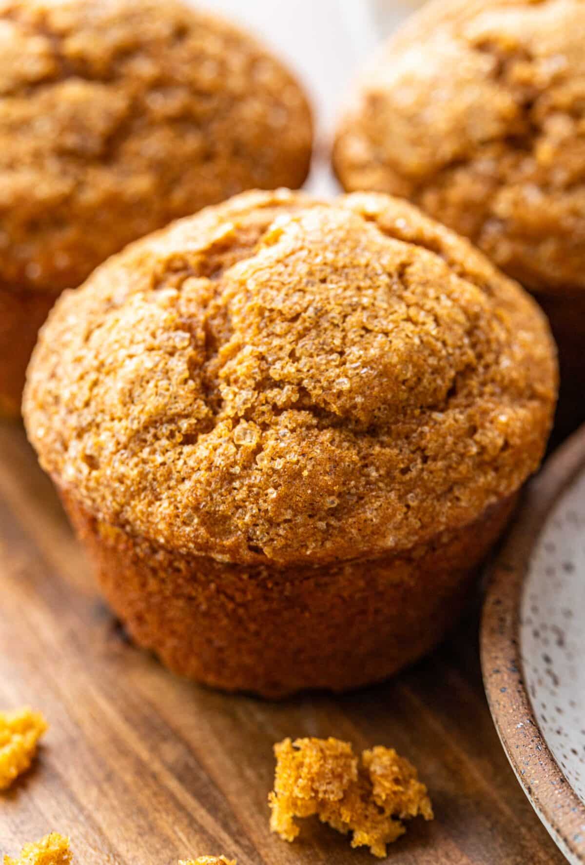 Pumpkin muffin with a few crumbs in front of it.