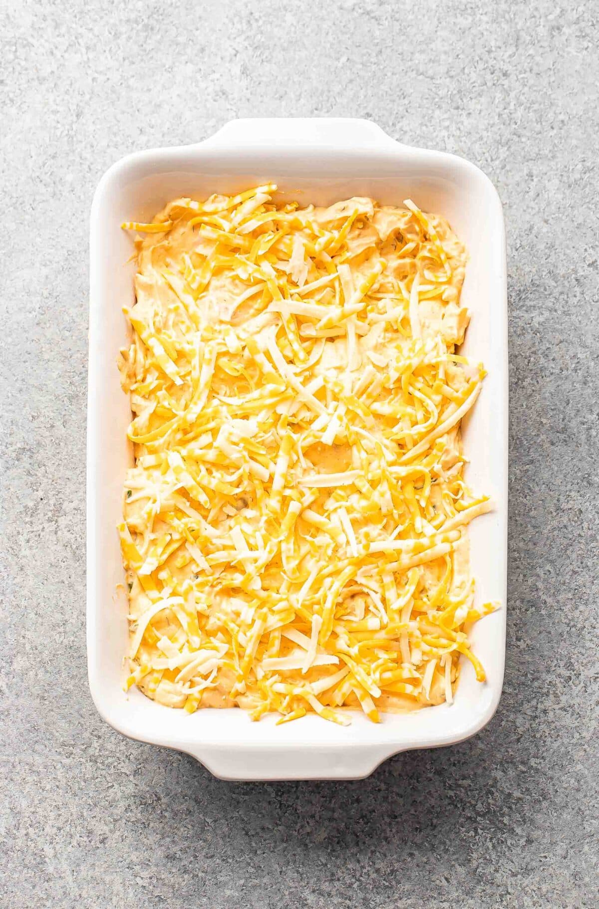 Buffalo chicken dip in a white casserole dish before being baked.