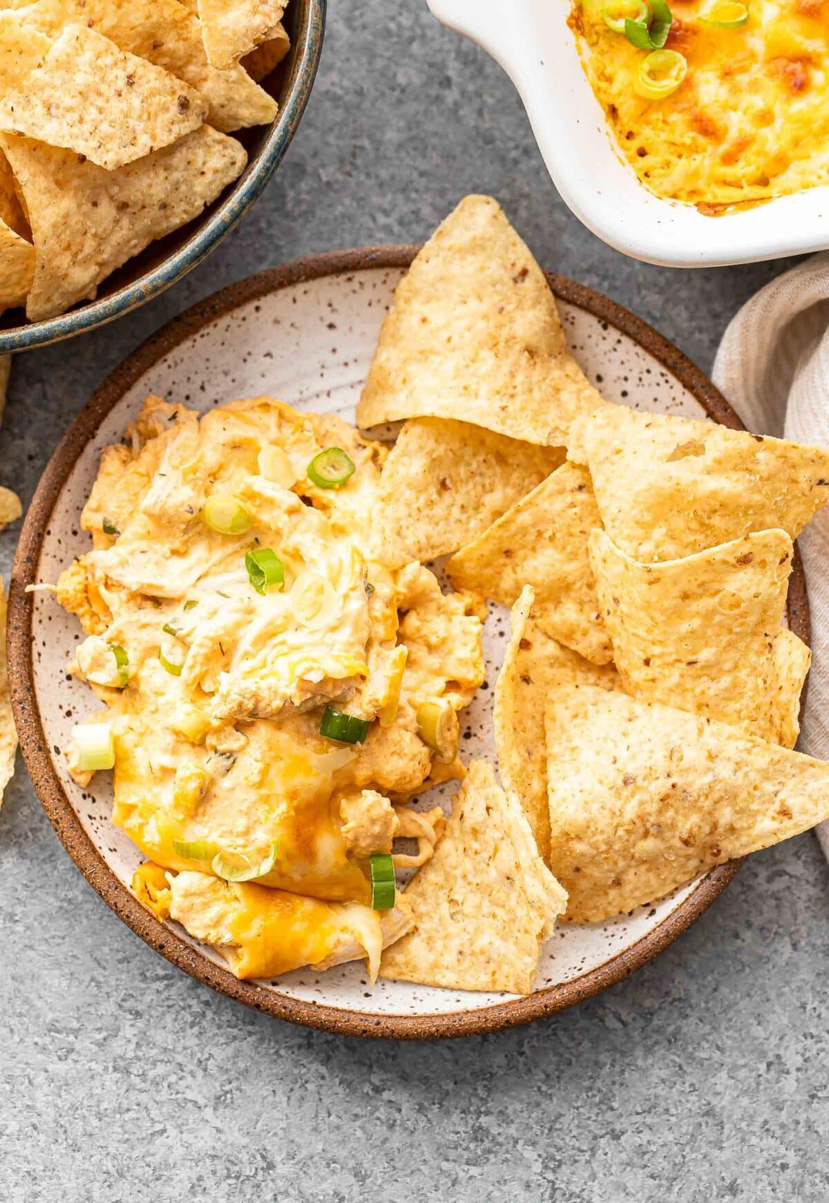 Buffalo chicken dip on a white plate with tortilla chips.