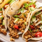 Ground turkey taco topped with lettuce, avocado chunks, and diced tomatoes.