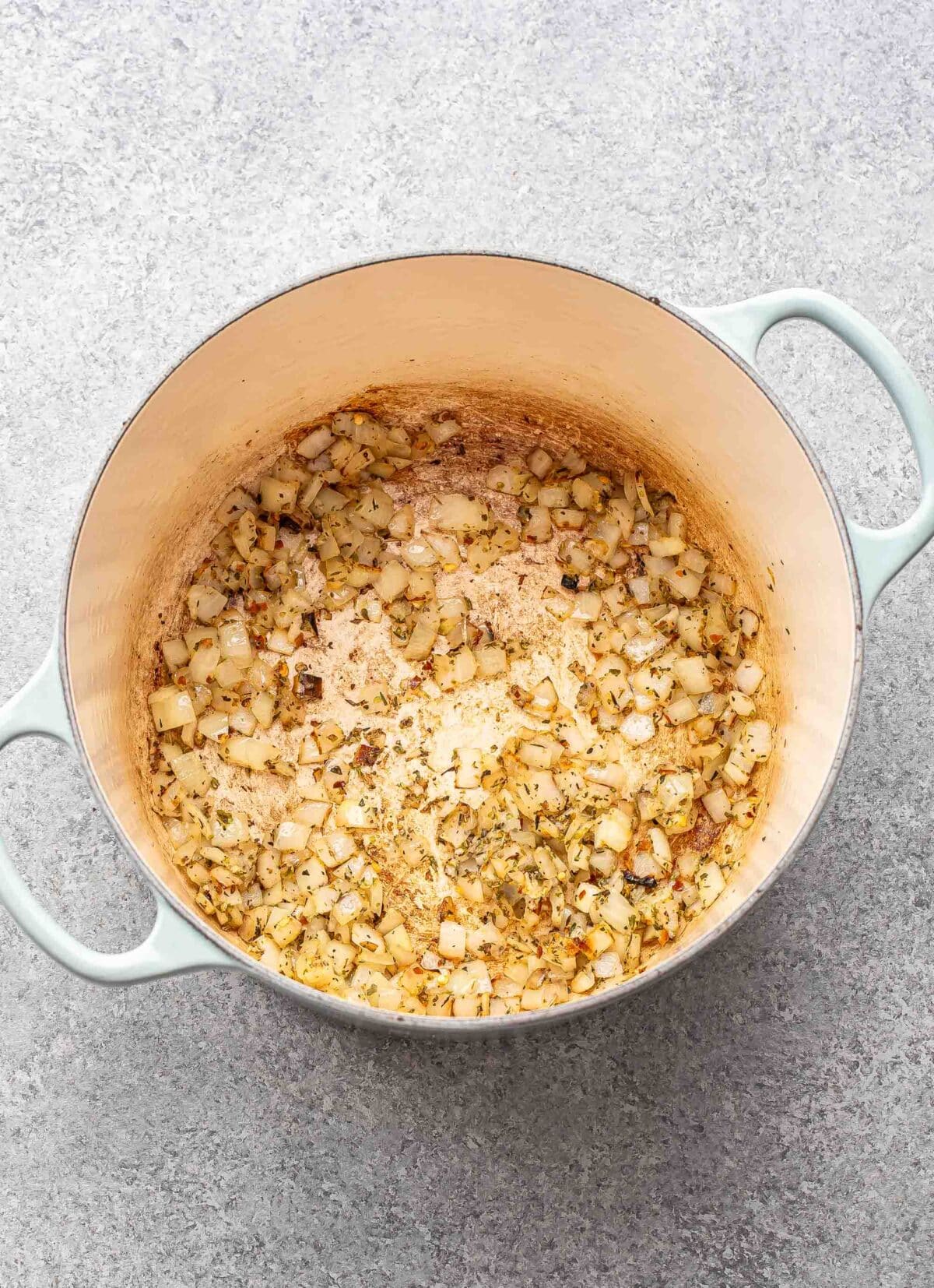 Cooked onions and garlic in a pot.