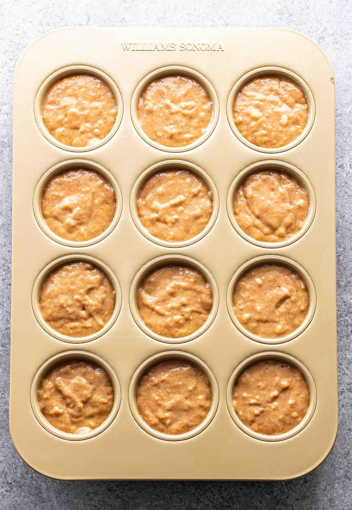 Unbaked banana muffins in a muffin pan.